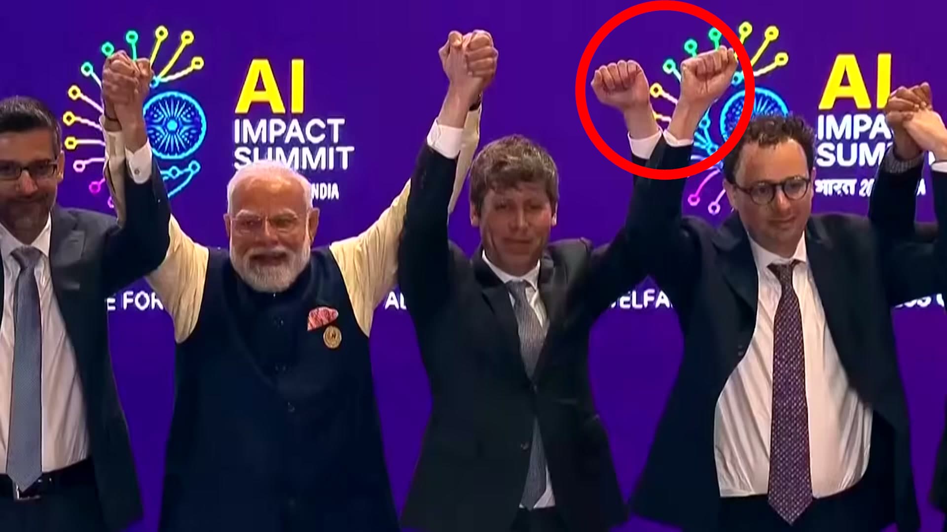 Sam Altman and Dario Amodei side by side but not joining hands while other tech leaders link up on stage at the India AI Summit, February 2026